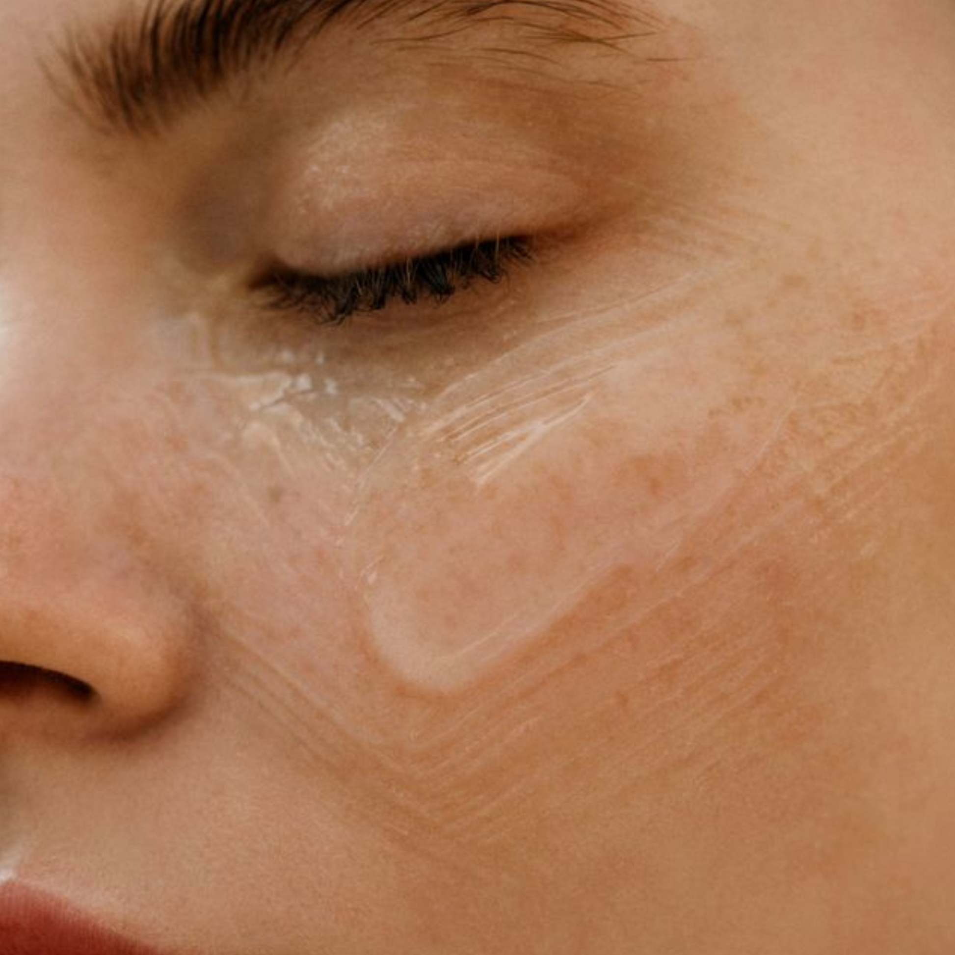 Visage avec du gel d’aloe vera appliqué sur la joue, soin apaisant et hydratant pour la peau, idéal pour calmer les irritations et nourrir en profondeur, texture translucide et effet frais visible.